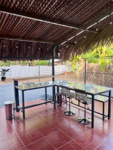 a table and chairs sitting under a roof at Modern Thatch in Ấp Phú Hòa (3) +5 photos
