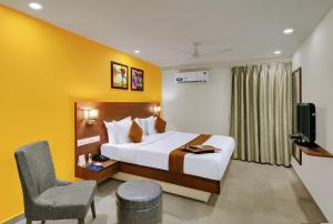 a hotel room with a bed and a chair at Best Western Alkapuri, Vadodara in Vadodara +72 photos