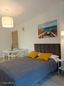 a bedroom with a large bed with yellow pillows at Villa Cork in Dębki