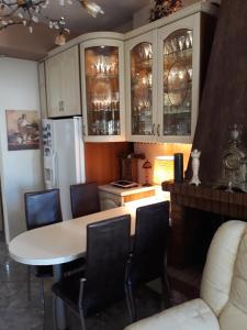 a kitchen with a table and chairs and a refrigerator at Mandy's cosy luxury flat in Piraeus +11 photos