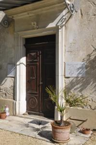 Charols的住宿－萊斯西加萊斯住宿加早餐旅館，前面有盆栽植物的建筑物的门