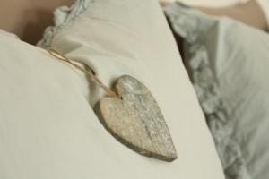 a wooden heart on the side of a bed at B&B Puur Drenthe in Elp