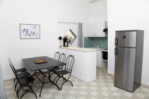 a small kitchen with a table and a refrigerator at Residenza l 'Alivetu in Cargèse