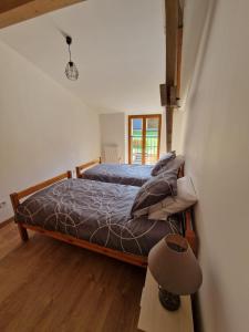 une chambre avec un lit et une lampe au sol dans l'établissement La Petite Maison d'Elodie, à Saint-Alvère