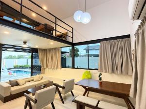 un salon avec un canapé et une table dans l'établissement Nibong Pool Villa by Cactus Homestay, à Johor Bahru