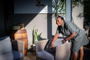 a woman is standing next to two chairs at Rafiki Bush Lodge in Hoedspruit +109 photos