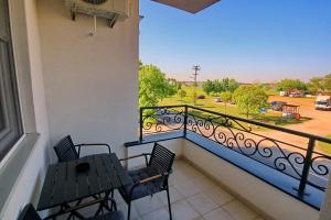 a balcony with two chairs and a view of a parking lot at White Diamond in Palić