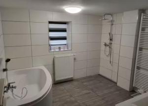 bagno con vasca, doccia e finestra di Schöne Ferienwohnung nähe Geiseltalsee a Bad Lauchstädt Altre 4 foto