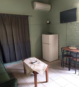 a kitchen with a white refrigerator and a table at TheOldHouse Seaview in Corfu