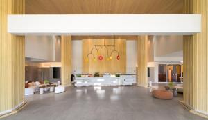 a large lobby with tables and chairs and a chandelier at Centara Karon Resort Phuket in Karon Beach