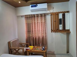 a room with a bed and a table and a air conditioner at Hotel Dhanmondi in Dhaka