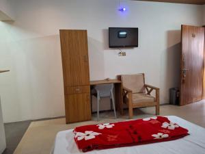 a bedroom with a bed and a desk and a television at Hotel Dhanmondi in Dhaka