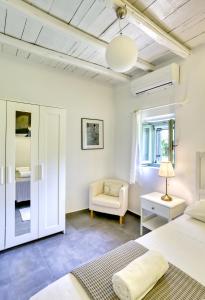 a bedroom with a bed and a chair at Mandarini House in Khokhlakiaí +41 photos