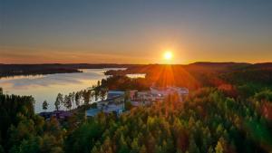 an aerial view of a town with a river and the sunset at Spa Hotel Peurunka in Laukaa