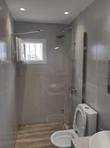a bathroom with a toilet and a sink at Family House - Παραθεριστικό Κατάλυμα in Nea Plagia +9 photos
