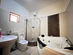 Un baño con bañera, inodoro y lavabo. en Horizon Sea View Apartments, en Mombasa 11 fotos más