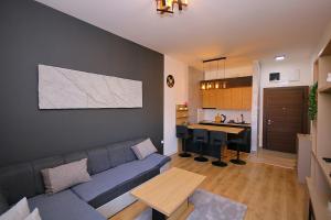 a living room with a blue couch and a kitchen at White Diamond in Palić +10 photos