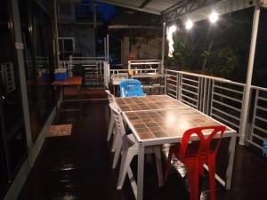 a table and chairs on a balcony at night at บ้านแฝด 2 ห้องนอน in Khao Kho