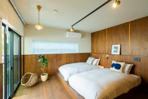 two beds in a room with wood paneling at HOTEL RIN TOKYO - Private Townhouse - in Tokyo