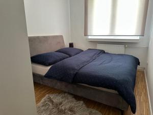a bedroom with a bed with blue pillows and a window at Przytulny Apartament z Balkonem Stalowa Wola in Stalowa Wola