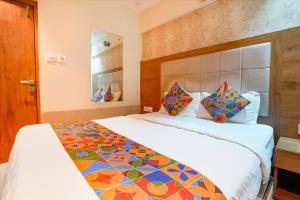 a bedroom with a large bed with a colorful blanket at FabHotel Regal Inn - In Sahar Road in Mumbai