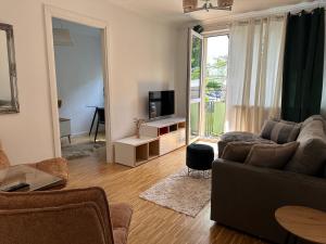 a living room with a couch and a television at Przytulny Apartament z Balkonem Stalowa Wola in Stalowa Wola
