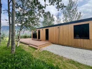 a house with a wooden exterior with a deck at Trollstigen Resort in Åndalsnes