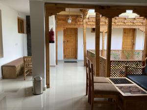 a living room with a table and chairs and a room at Himalayan Regal House in Deskit