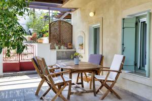 a wooden table and chairs on a patio at Mandarini House in Khokhlakiaí