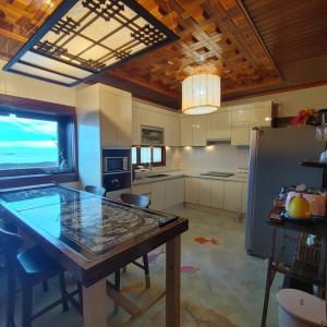 a kitchen with a table and a refrigerator at Gimnyeong Home in Jeju +37 photos