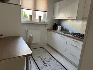 a small kitchen with white cabinets and a sink at Przytulny Apartament z Balkonem Stalowa Wola in Stalowa Wola