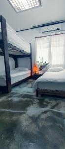 a bedroom with two bunk beds and a window at Gimnyeong Home in Jeju