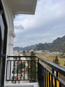 a balcony with a view of a city and mountains at New Sun Hotel in Dồng Văn +8 photos