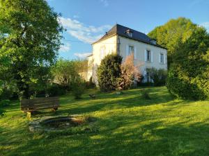 a white house with a bench in the grass at Terre de Plaisirs in Forgès +9 photos