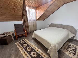 a bedroom with a bed and a chair at Casa Mis in Baia de Fier