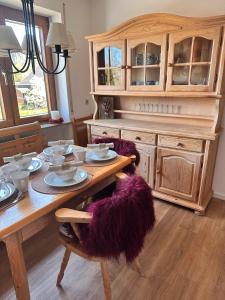 un comedor con una mesa de madera con sillas moradas en Schöne große Wohnung - Top Lage, en Ravensburg