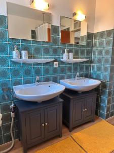 Un baño con dos lavabos y una pared de azulejos azules. en Schöne große Wohnung - Top Lage, en Ravensburg