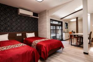 two beds in a room with a table and a desk at Kyomachiya Bettei Hanatei in Kyoto