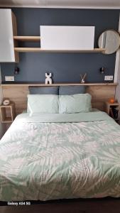 a bedroom with a bed with a blue wall at Charmant mobil home camping Les Embruns in Lège-Cap-Ferret