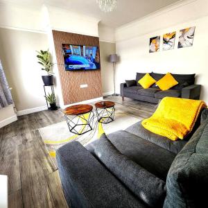 a living room with a couch and a tv at The Bishopsworth House in Bristol
