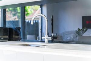a kitchen sink with a faucet next to a window at The Bishopsworth House in Bristol +22 photos