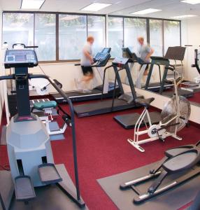 a gym with several people exercising on tread machines at Amsterdam Hotel in Stamford