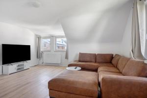 a living room with a couch and a flat screen tv at Ferienwohnung Fischerhaus in Wasserburg am Bodensee