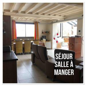 Una gran sala de estar con un sofá y una mesa. en Les Jardins d'Omaha, en Saint-Laurent-sur-Mer