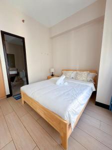 a bedroom with a large bed with white sheets at OPR High- floor Seaview Studio in Lapu Lapu City