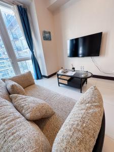 a living room with a couch and a tv at OPR High- floor Seaview Studio in Lapu Lapu City