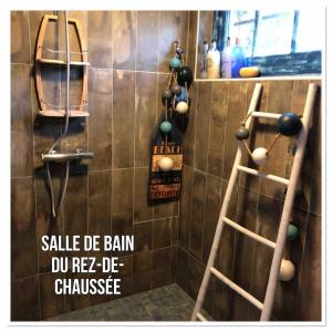 Un baño con dos escaleras de madera y una pared con bolas. en Les Jardins d'Omaha, en Saint-Laurent-sur-Mer