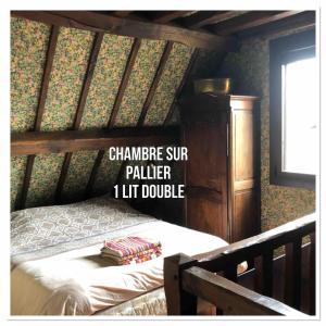 1 dormitorio con 1 cama con cuna de madera en Les Jardins d'Omaha, en Saint-Laurent-sur-Mer