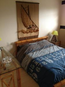 Un dormitorio con una cama con un cuadro en la pared. en Les Jardins d'Omaha, en Saint-Laurent-sur-Mer