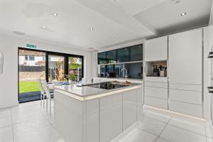 a kitchen with white cabinets and a table with chairs at The Bishopsworth House in Bristol